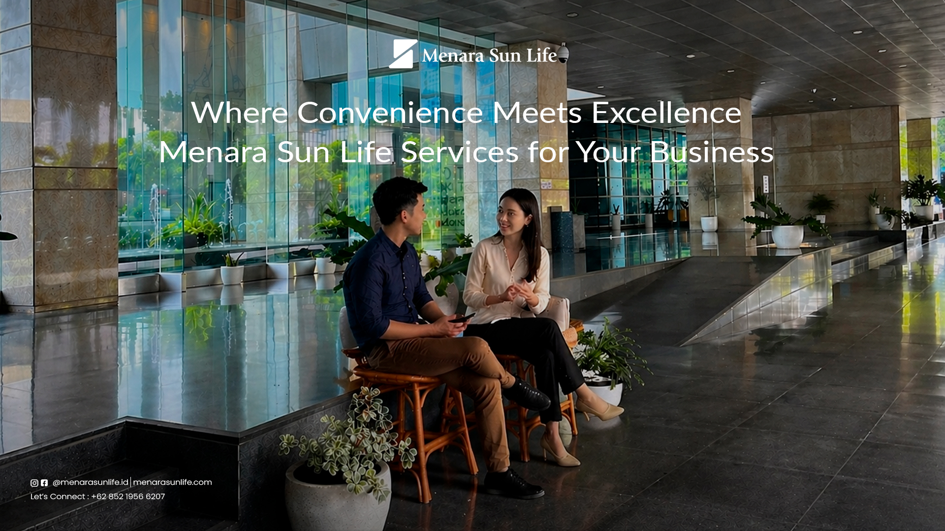 Two professionals having a conversation in the spacious, stylish lobby of Menara Sun Life, showcasing a modern and convenient environment for business.