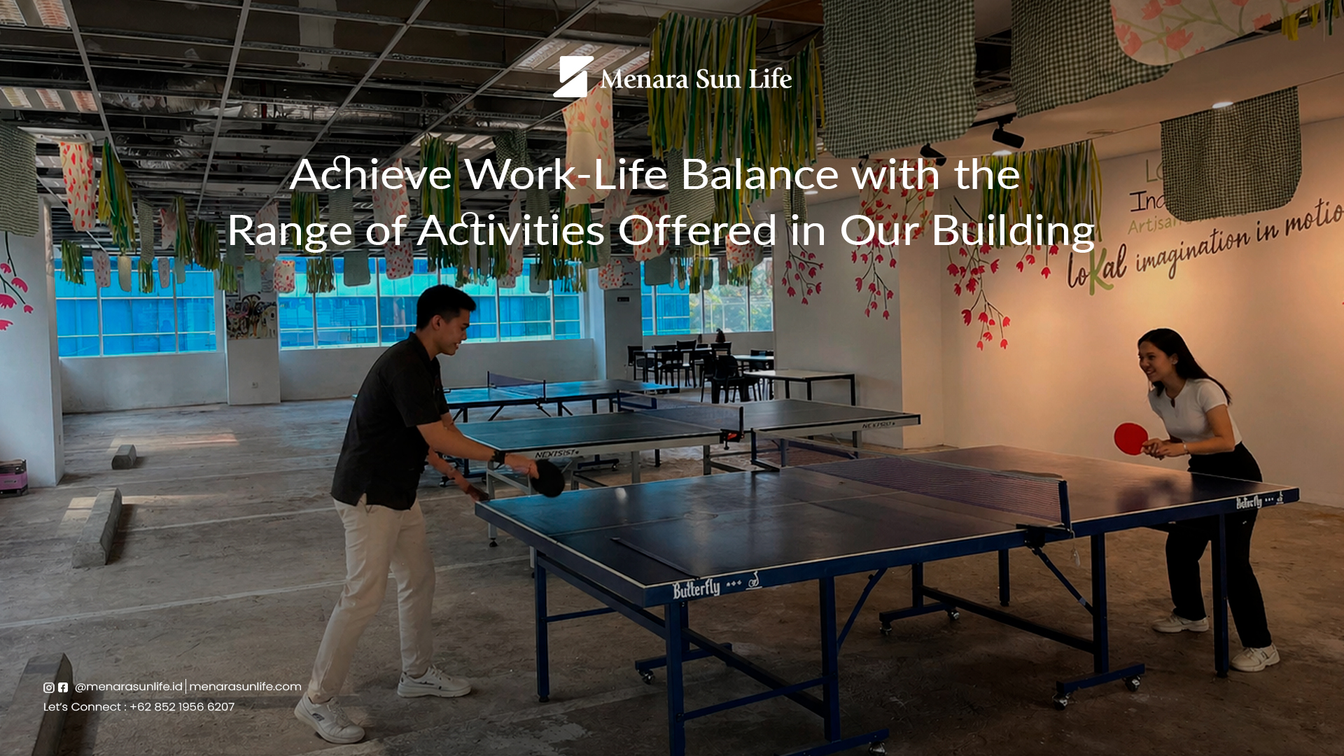 Two young professionals playing table tennis in a recreational area inside Menara Sun Life, highlighting a fun and balanced workplace environment.
